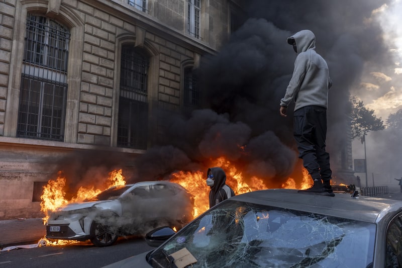 Un manifestante observa cómo arde un coche durante una protesta en París, el 17 de octubre. Fotógrafo: Nathan Laine/Bloomberg Un manifestante observa cómo arde un coche durante una protesta en París, el 17 de octubre. Fotógrafo: Nathan Laine/Bloomberg