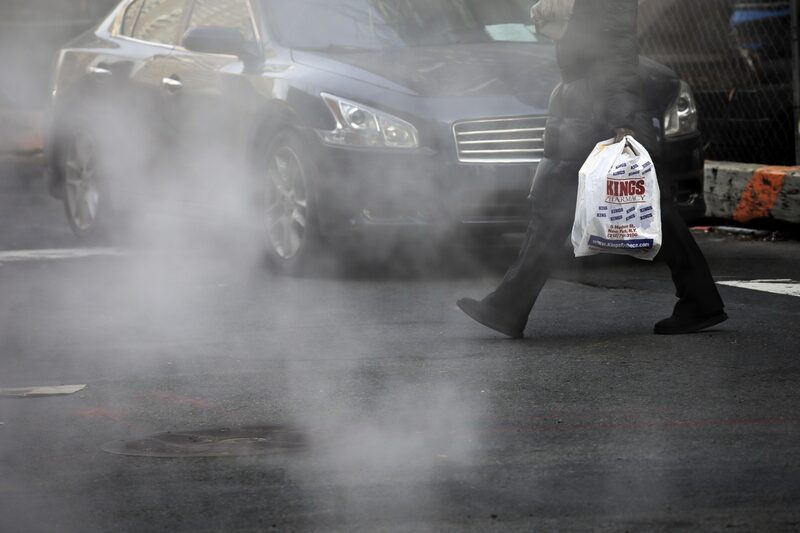 Un hombre caminando con una bolsa plástica en su mano Un hombre caminando con una bolsa plástica en su mano