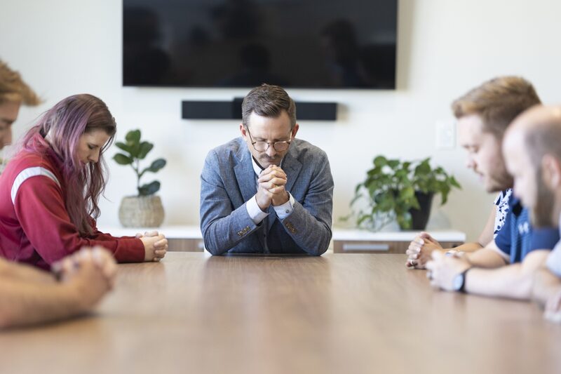 Robert Netzly dirige a los empleados en una oración antes de una reunión en Inspire Investing en Meridian, Idaho. Robert Netzly dirige a los empleados en una oración antes de una reunión en Inspire Investing en Meridian, Idaho.