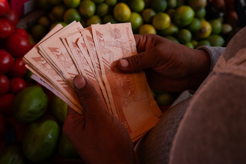 Una mujer cuenta billetes bolívares en el mercado de Coche en Caracas. Foto: Bloomberg Una mujer cuenta billetes bolívares en el mercado de Coche en Caracas. Foto: Bloomberg