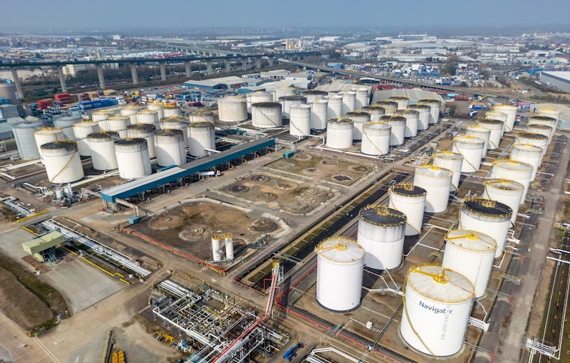 Vista aérea de una instalación de almacenamiento de combustibles, con decenas de tanques y redes de tuberías. Vista aérea de una instalación de almacenamiento de combustibles, con decenas de tanques y redes de tuberías.