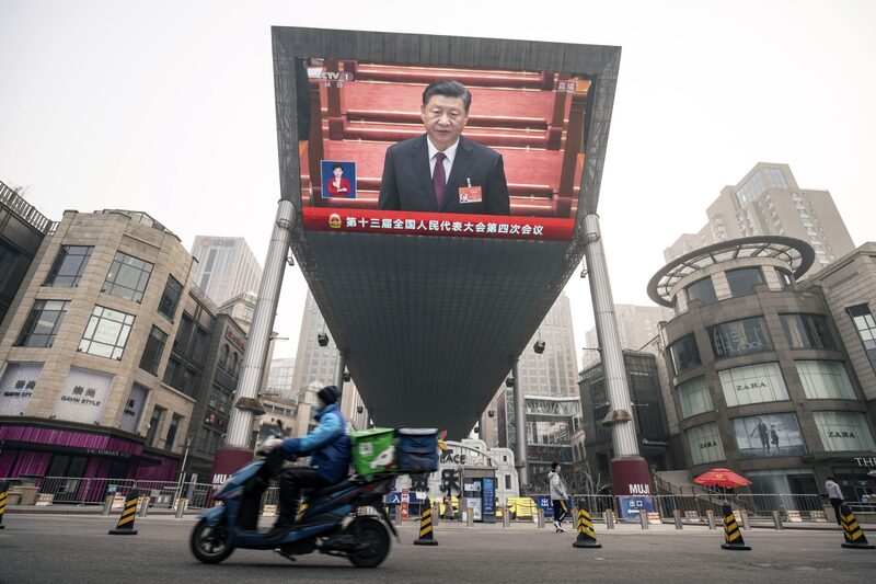 Un repartidor conduce una motocicleta frente a una pantalla que muestra una transmisión de noticias en vivo del presidente chino Xi Jinping en la Asamblea Popular Nacional en Beijing, China. Fotógrafo: Qilai Shen/Bloomberg Un repartidor conduce una motocicleta frente a una pantalla que muestra una transmisión de noticias en vivo del presidente chino Xi Jinping en la Asamblea Popular Nacional en Beijing, China. Fotógrafo: Qilai Shen/Bloomberg
