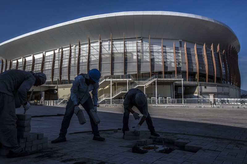 Workers install paving stones at the Olympic Village in the Barra da Tijuca neighborhood of Rio de Janeiro, Brazil, on Monday, April 4, 2016. In what is emerging as a rare bright spot in a country buffeted by crisis on all sides, the Olympic Committee is saying that more than 95 percent of the venues are complete some four months ahead of the opening ceremony and, whats more, data shows spending has largely remained under control. Photographer: Dado Galdieri/Bloomberg Workers install paving stones at the Olympic Village in the Barra da Tijuca neighborhood of Rio de Janeiro, Brazil, on Monday, April 4, 2016. In what is emerging as a rare bright spot in a country buffeted by crisis on all sides, the Olympic Committee is saying that more than 95 percent of the venues are complete some four months ahead of the opening ceremony and, whats more, data shows spending has largely remained under control. Photographer: Dado Galdieri/Bloomberg