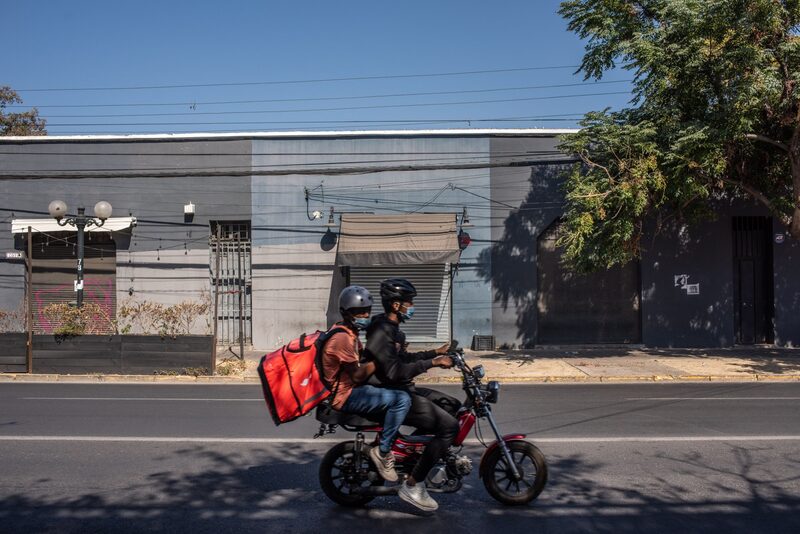 Delivery workers rides a motorcycle during lockdown in Santiago, Chile, on Monday, March 29, 2021. Chile has been vaccinating its population much faster than all other countries in Latin America, with more than 6 million inoculated, though the nation has still seen its daily record number of cases increase. Photographer: Cristobal Olivares/Bloomberg Delivery workers rides a motorcycle during lockdown in Santiago, Chile, on Monday, March 29, 2021. Chile has been vaccinating its population much faster than all other countries in Latin America, with more than 6 million inoculated, though the nation has still seen its daily record number of cases increase. Photographer: Cristobal Olivares/Bloomberg