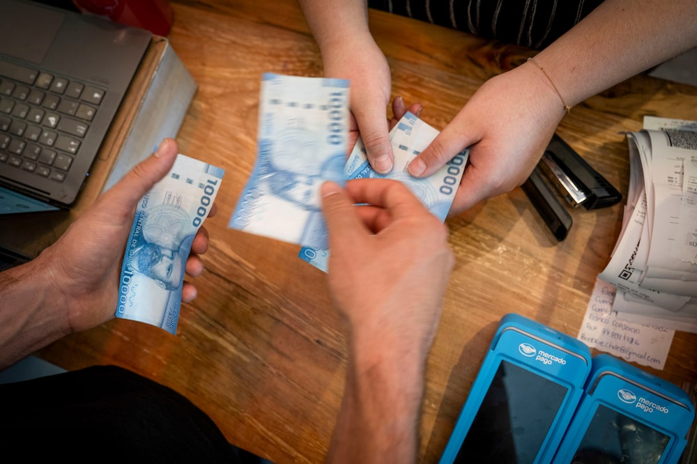 A customer pays in Chilean peso notes at a store in Santiago, Chile, on Monday, Jan. 6, 2025. Chiles central bank said its future monetary policy decisions should consider significant risks including short-term inflation challenges, according to the minutes to its last key rate meeting. Photographer: Tamara Merino/Bloomberg A customer pays in Chilean peso notes at a store in Santiago, Chile, on Monday, Jan. 6, 2025. Chiles central bank said its future monetary policy decisions should consider significant risks including short-term inflation challenges, according to the minutes to its last key rate meeting. Photographer: Tamara Merino/Bloomberg