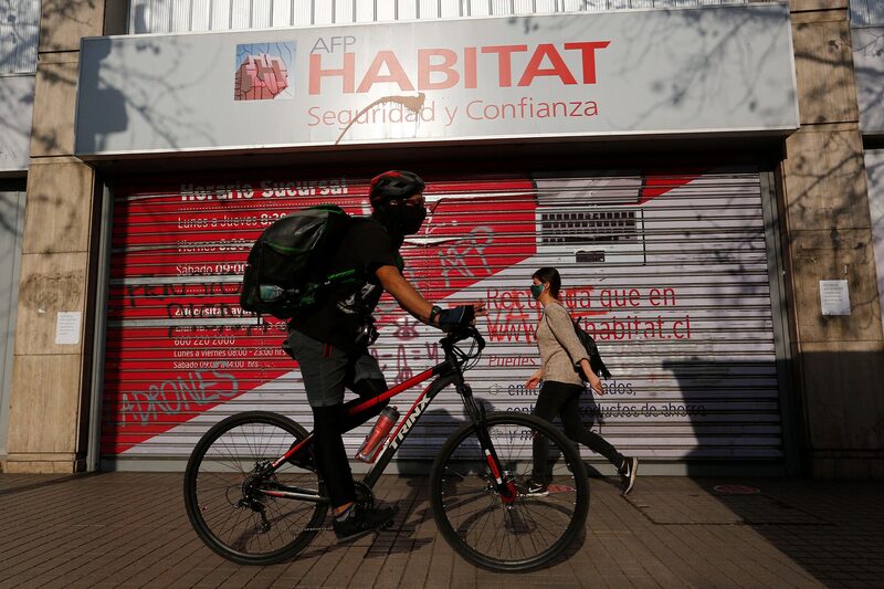 Personas pasan frente a una oficina AFP (administradora de fondos de pensiones) en Santiago, Chile. Personas pasan frente a una oficina AFP (administradora de fondos de pensiones) en Santiago, Chile.