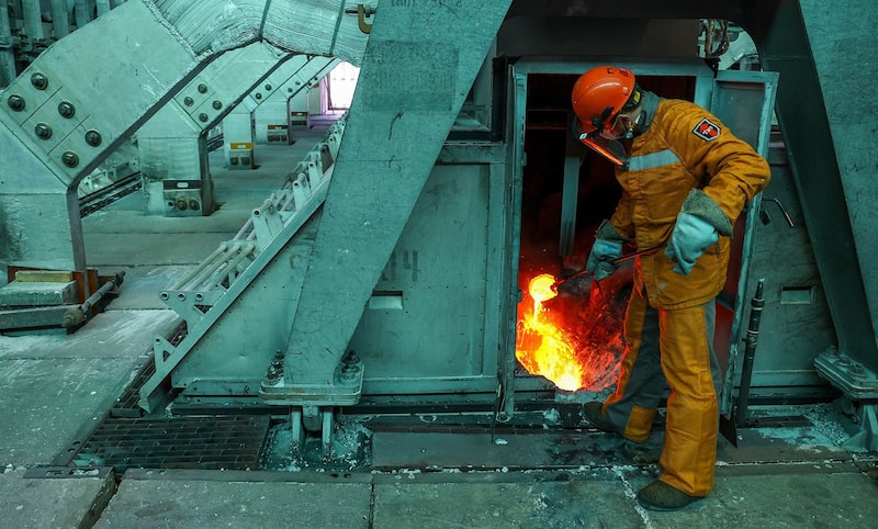 A worker takes a sample of liquid aluminum from an electrolysis bath in the electrolysis shop at the Khakas aluminium smelter, in Sayanogorsk, Russia. A worker takes a sample of liquid aluminum from an electrolysis bath in the electrolysis shop at the Khakas aluminium smelter, in Sayanogorsk, Russia.