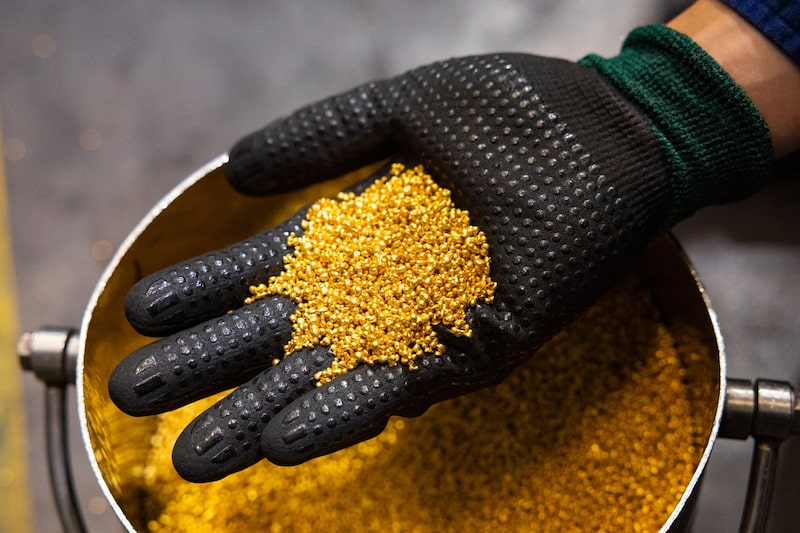 Un trabajador sostiene gránulos de oro en la refinería de la Casa de la Moneda de Perth, en Perth (Australia). Fotógrafo: Matt Jelonek/Bloomberg Un trabajador sostiene gránulos de oro en la refinería de la Casa de la Moneda de Perth, en Perth (Australia). Fotógrafo: Matt Jelonek/Bloomberg
