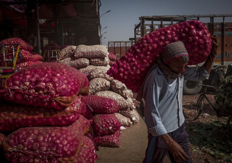 Un trabajador transporta un saco de cebollas en un mercado mayorista de Nueva Delhi, India. Fotógrafo: Anindito Mukherjee/Bloomberg Un trabajador transporta un saco de cebollas en un mercado mayorista de Nueva Delhi, India. Fotógrafo: Anindito Mukherjee/Bloomberg