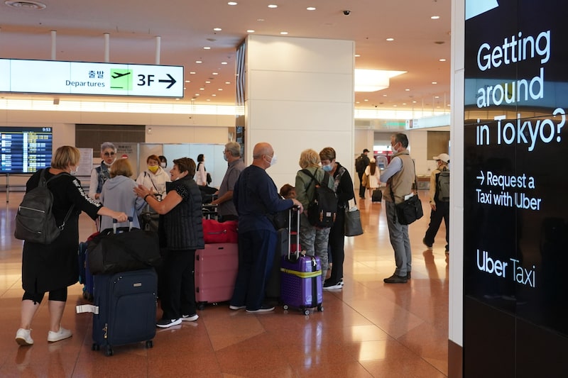 Pasajeros con equipaje se reúnen en el vestíbulo de llegadas del aeropuerto de Haneda en Tokio, Japón, el martes 11 de octubre de 2022. Pasajeros con equipaje se reúnen en el vestíbulo de llegadas del aeropuerto de Haneda en Tokio, Japón, el martes 11 de octubre de 2022.