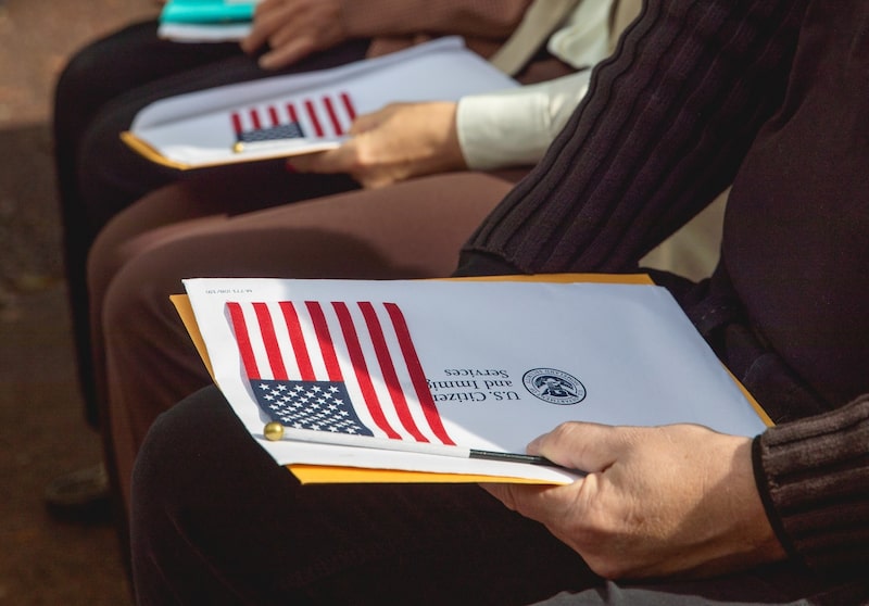 Una foto referencial muestra a personas con sobres del USCIS. Una foto referencial muestra a personas con sobres del USCIS.