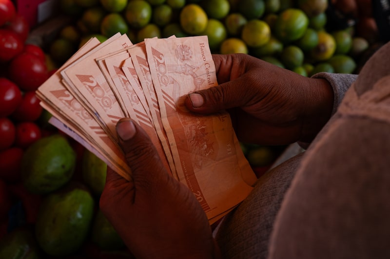 Una mujer cuenta billetes de bolívares en el mercado de Coche en Caracas, Venezuela, el martes 20 de agosto de 2024. Una mujer cuenta billetes de bolívares en el mercado de Coche en Caracas, Venezuela, el martes 20 de agosto de 2024.