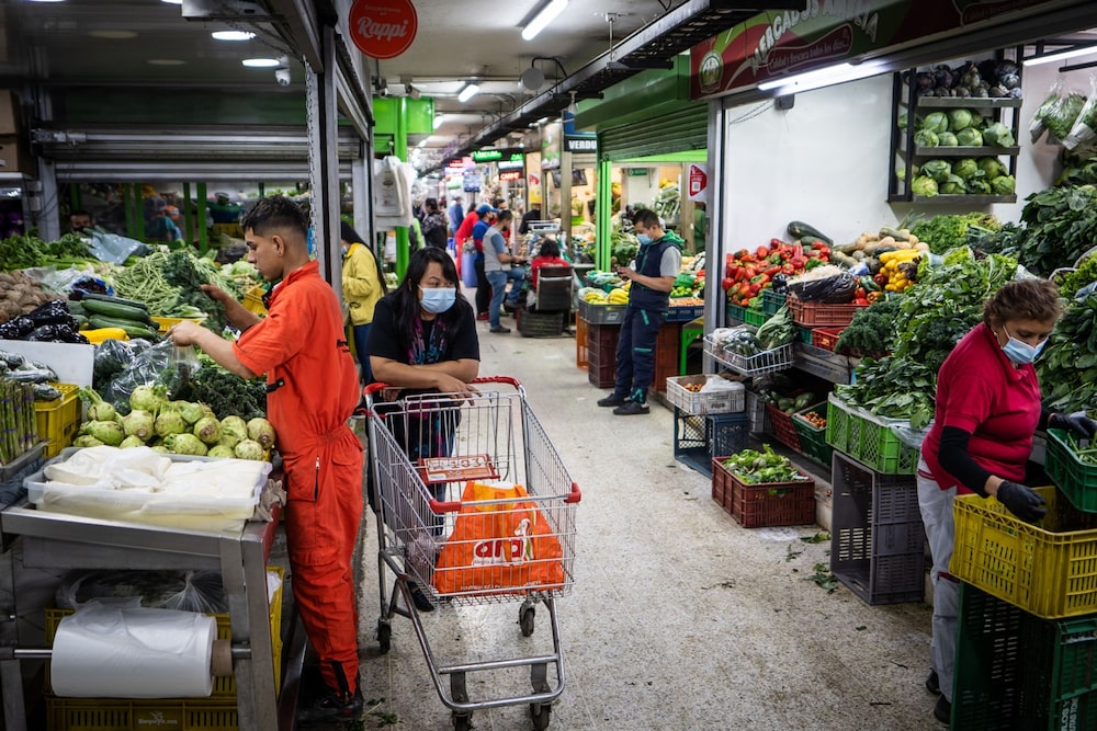 Un trabajador asiste a un cliente en un mercado de productos agrícolas en Bogotá, Colombia, el lunes 7 de febrero de 2022. Un trabajador asiste a un cliente en un mercado de productos agrícolas en Bogotá, Colombia, el lunes 7 de febrero de 2022.