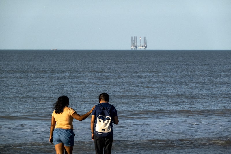 Visitantes caminan por la playa norte, frente a una plataforma petrolera de Pemex en la costa de Ciudad del Carmen, en el estado de Campeche, México. Visitantes caminan por la playa norte, frente a una plataforma petrolera de Pemex en la costa de Ciudad del Carmen, en el estado de Campeche, México.