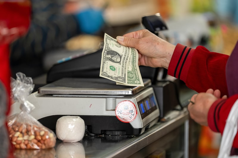 Un comprador con billetes de un dólar estadounidense dentro de una tienda. Fotógrafo: David Paul Morris/Bloomberg Un comprador con billetes de un dólar estadounidense dentro de una tienda. Fotógrafo: David Paul Morris/Bloomberg