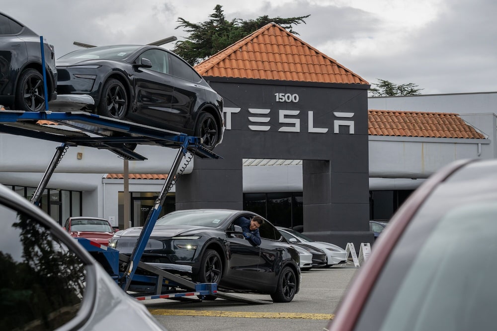 Un conductor de transporte de vehículos descarga vehículos Tesla Model Y en la tienda de la compañía en Colma, California. Un conductor de transporte de vehículos descarga vehículos Tesla Model Y en la tienda de la compañía en Colma, California.