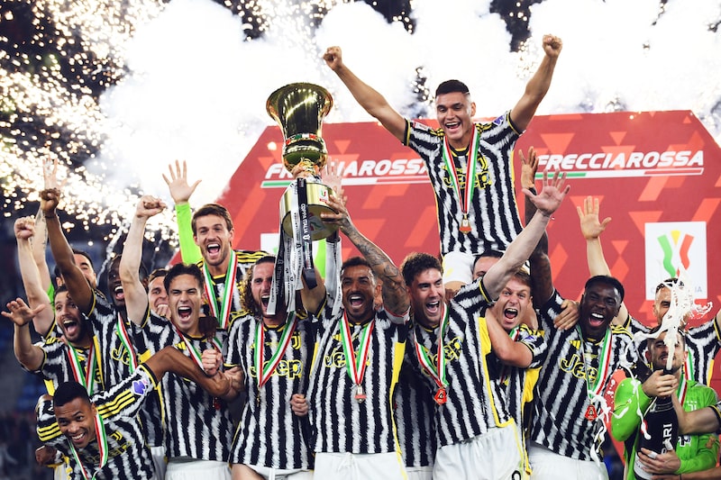 El defensa brasileño del Juventus #06 Danilo sostiene el trofeo mientras los jugadores del Juventus celebran la victoria en la final de la Copa de Italia entre el Atalanta y el Juventus en el Estadio Olímpico de Roma el 15 de mayo de 2024. El defensa brasileño del Juventus #06 Danilo sostiene el trofeo mientras los jugadores del Juventus celebran la victoria en la final de la Copa de Italia entre el Atalanta y el Juventus en el Estadio Olímpico de Roma el 15 de mayo de 2024.