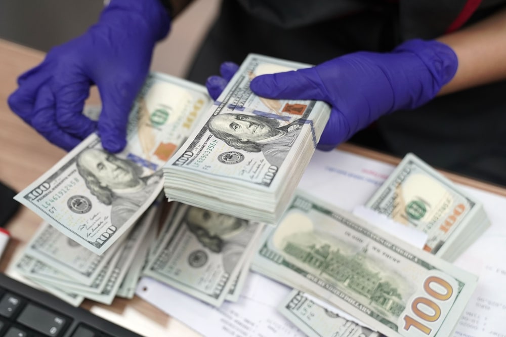 Un empleado, que lleva puestos guantes de protección, cuenta billetes de dólar estadounidense en una casa de cambio PT Ayu Masagung en Yakarta, Indonesia. Un empleado, que lleva puestos guantes de protección, cuenta billetes de dólar estadounidense en una casa de cambio PT Ayu Masagung en Yakarta, Indonesia.
