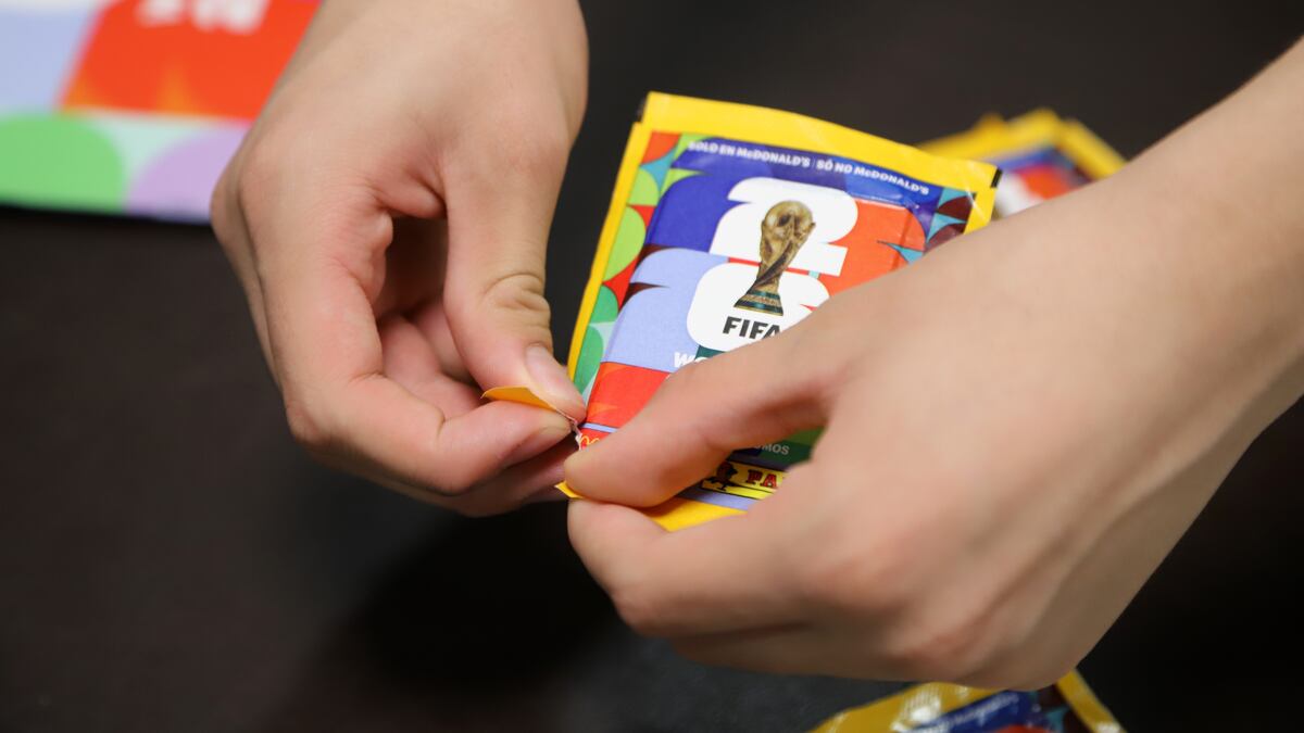 Persona abriendo un paquete de pegatinas para la Copa Mundial de la FIFA 2026.