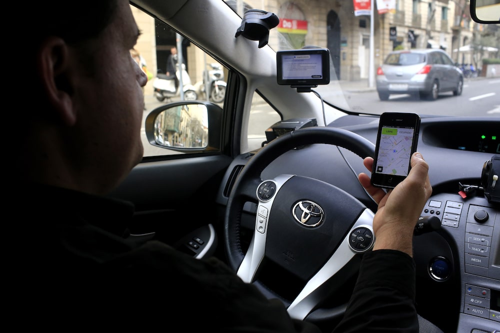A driver checks a navigation app on his smartphone while driving in Barcelona, Spain, on Wednesday, Feb. 25, 2015. As executives from the world's biggest phone companies gather in Barcelona next week, much of their focus will be on the $1.7 trillion they're spending as they upgrade to fourth-generation wireless technology. Photographer: Pau Barrena/Bloomberg A driver checks a navigation app on his smartphone while driving in Barcelona, Spain, on Wednesday, Feb. 25, 2015. As executives from the world's biggest phone companies gather in Barcelona next week, much of their focus will be on the $1.7 trillion they're spending as they upgrade to fourth-generation wireless technology. Photographer: Pau Barrena/Bloomberg