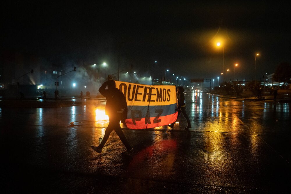Los manifestantes sostienen una bandera colombiana que dice "queremos la paz" durante una protesta en Bogotá, Colombia, el viernes 28 de mayo de 2021. Los manifestantes sostienen una bandera colombiana que dice "queremos la paz" durante una protesta en Bogotá, Colombia, el viernes 28 de mayo de 2021.