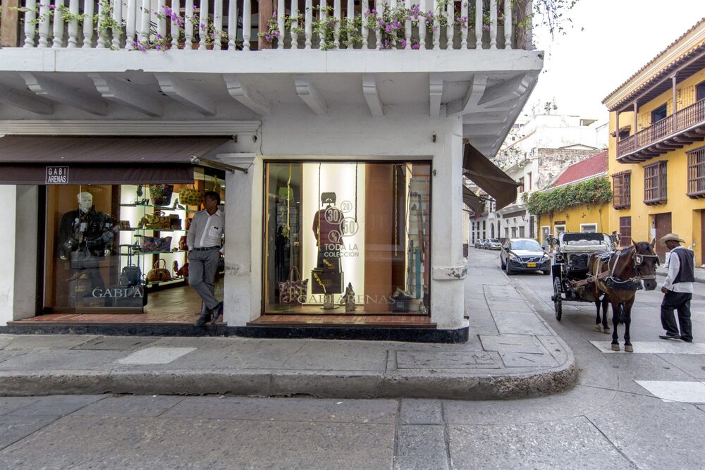 An employee stands in the doorway of a clothing store in Cartagena, Colombia. An employee stands in the doorway of a clothing store in Cartagena, Colombia.