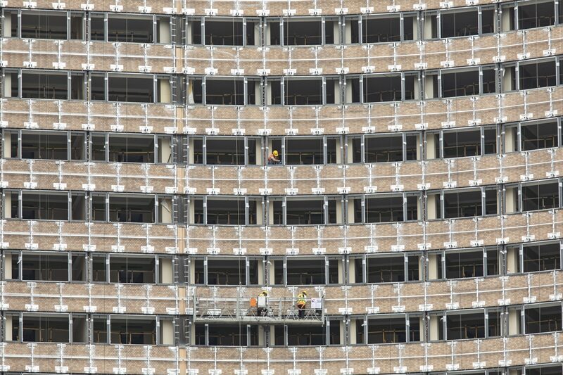 Construction workers operate on a platform at a hotel renovation project in Shanghai, China. Construction workers operate on a platform at a hotel renovation project in Shanghai, China.