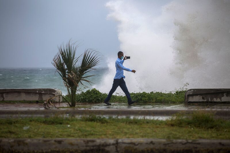 Un hombre graba un video del fuerte oleaje durante el paso de la tormenta Elsa en el Malecón de Santo Domingo, el 3 de julio de 2021. Un hombre graba un video del fuerte oleaje durante el paso de la tormenta Elsa en el Malecón de Santo Domingo, el 3 de julio de 2021.