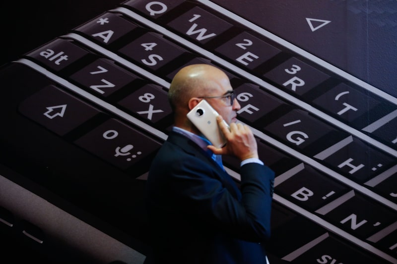 Una persona pasa por delante de un cartel de BlackBerry Una persona pasa por delante de un cartel de BlackBerry