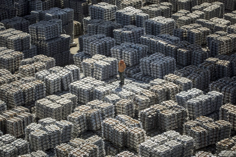 Un trabajador se encuentra sobre paquetes de lingotes de aluminio en un almacén de China National Materials Storage and Transportation Corp. en Wuxi, China, el jueves 23 de agosto de 2018. Un trabajador se encuentra sobre paquetes de lingotes de aluminio en un almacén de China National Materials Storage and Transportation Corp. en Wuxi, China, el jueves 23 de agosto de 2018.
