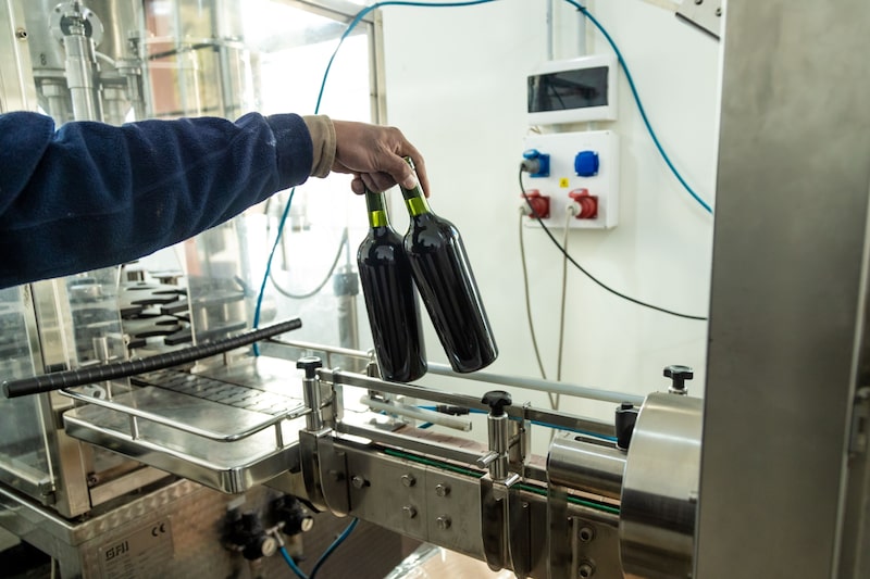 A worker holds unlabeled bottles of wine at the San Pedro de Yacochuya vineyard in Cafayate, Argentina. A worker holds unlabeled bottles of wine at the San Pedro de Yacochuya vineyard in Cafayate, Argentina.