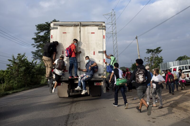 Migrantes hondureños suben a un camión mientras viajan a la frontera con Guatemala cerca de La Entrada, Honduras, el viernes 15 de enero de 2021. Migrantes hondureños suben a un camión mientras viajan a la frontera con Guatemala cerca de La Entrada, Honduras, el viernes 15 de enero de 2021.