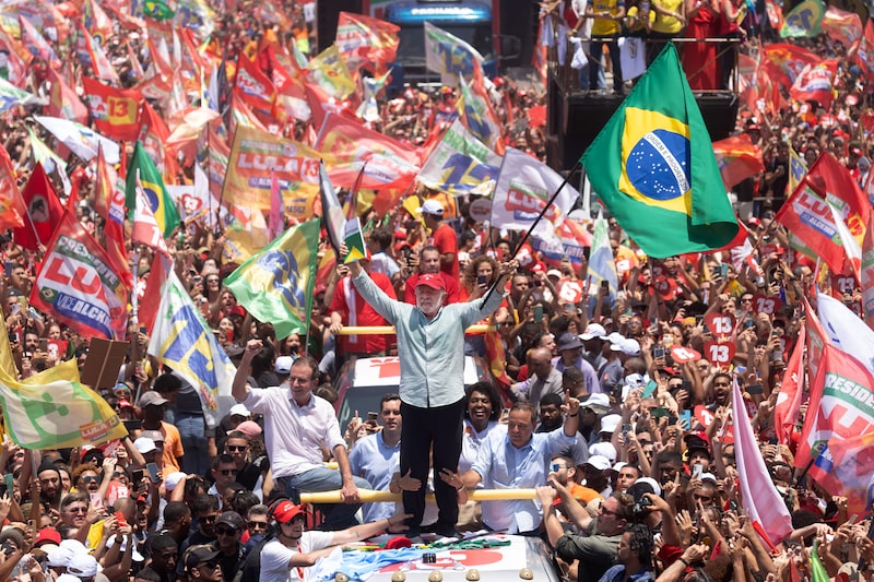Luiz Inacio Lula da Silva, Brazil's president, center, holds a copy of the Brazilian Constitution and the national flag during a closing campaign rally at Copacabana Beach in Rio de Janeiro, Brazil, on Saturday, Oct. 24, 2026. Flavio Bolsonaro and President Lula are tied just days before Brazil's Sunday runoff election, a new poll showed. Photographer: Dado Galdieri/Bloomberg Luiz Inacio Lula da Silva, Brazil's president, center, holds a copy of the Brazilian Constitution and the national flag during a closing campaign rally at Copacabana Beach in Rio de Janeiro, Brazil, on Saturday, Oct. 24, 2026. Flavio Bolsonaro and President Lula are tied just days before Brazil's Sunday runoff election, a new poll showed. Photographer: Dado Galdieri/Bloomberg