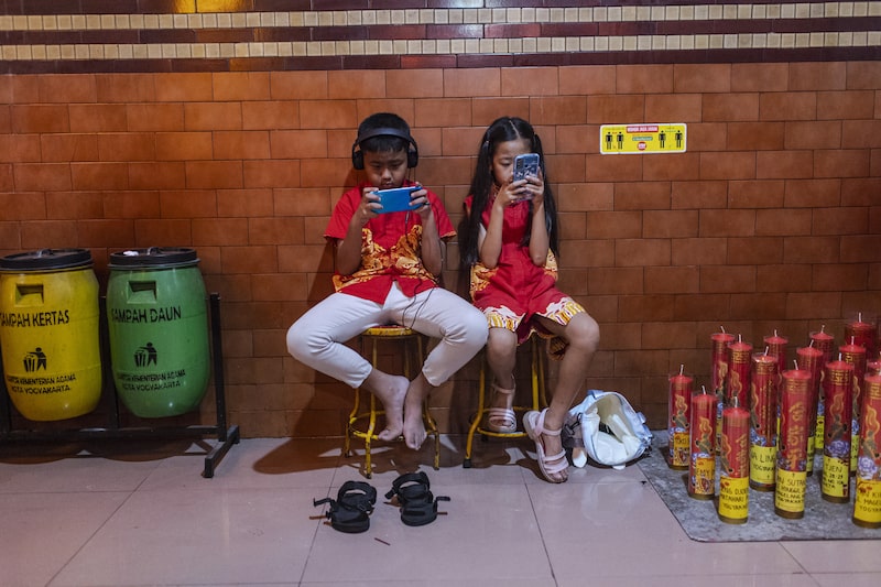 Crianças usam seus smartphones durante as comemorações da véspera do Ano Novo Lunar no templo Fuk Ling Miau, em 28 de janeiro de 2025, em Yogyakarta, na Indonésia. Crianças usam seus smartphones durante as comemorações da véspera do Ano Novo Lunar no templo Fuk Ling Miau, em 28 de janeiro de 2025, em Yogyakarta, na Indonésia.