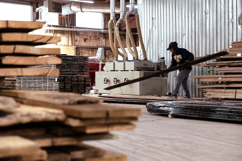 Un trabajador utiliza una máquina de cepillado para restaurar revestimientos de madera reciclada en un aserradero en Nueva York. Un trabajador utiliza una máquina de cepillado para restaurar revestimientos de madera reciclada en un aserradero en Nueva York.