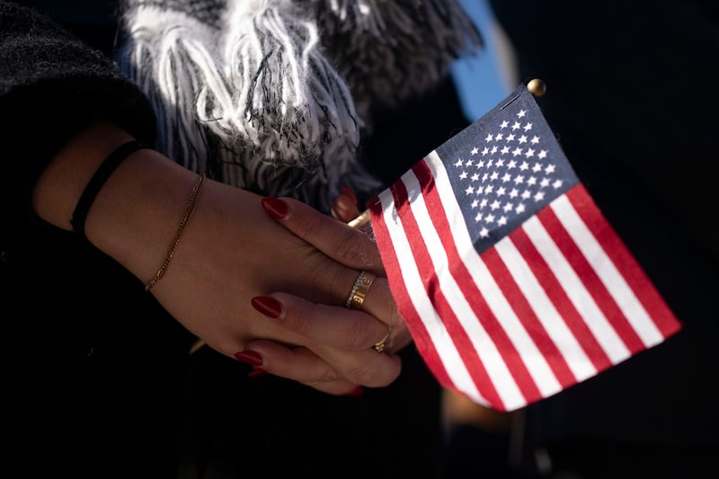 Una mujer sostiene una bandera estadounidense durante la ceremonia de conmemoración del Día Nacional de los Veteranos en el Anfiteatro Conmemorativo del Cementerio Nacional de Arlington, Virginia, EE.UU., el sábado 11 de noviembre de 2023. Una mujer sostiene una bandera estadounidense durante la ceremonia de conmemoración del Día Nacional de los Veteranos en el Anfiteatro Conmemorativo del Cementerio Nacional de Arlington, Virginia, EE.UU., el sábado 11 de noviembre de 2023.