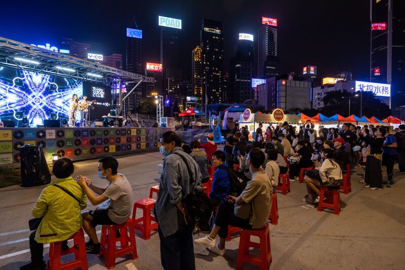 Visitantes escuchan una actuación musical en un mercado nocturno de Hong Kong, China. Visitantes escuchan una actuación musical en un mercado nocturno de Hong Kong, China.