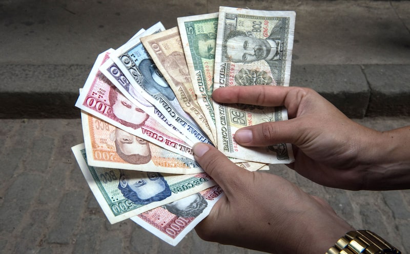 O governo definiu a nova taxa a 410 pesos cubanos por dólar — muito mais fraco do que as duas taxas de câmbio existentes na ilha, de 24 e 120 pesos por dólar O governo definiu a nova taxa a 410 pesos cubanos por dólar — muito mais fraco do que as duas taxas de câmbio existentes na ilha, de 24 e 120 pesos por dólar