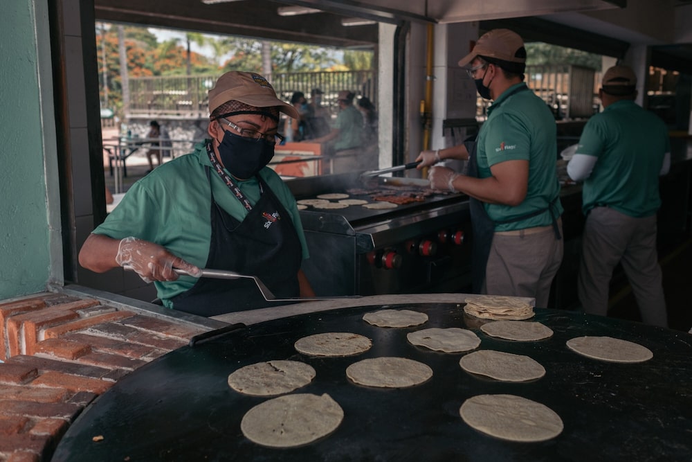 Workers wearing protective masks prepare food in a restaurant at the Six Flags Hurricane Harbor water park in Oaxtepec, Morelos state, Mexico, on Saturday, Sept. 12, 2020. Mexico reported 5,674 new Covid-19 cases, bringing the total to 663,973, according to data released by the Health Ministry Saturday night. Photographer: Jeoffrey Guillemard/Bloomberg Workers wearing protective masks prepare food in a restaurant at the Six Flags Hurricane Harbor water park in Oaxtepec, Morelos state, Mexico, on Saturday, Sept. 12, 2020. Mexico reported 5,674 new Covid-19 cases, bringing the total to 663,973, according to data released by the Health Ministry Saturday night. Photographer: Jeoffrey Guillemard/Bloomberg