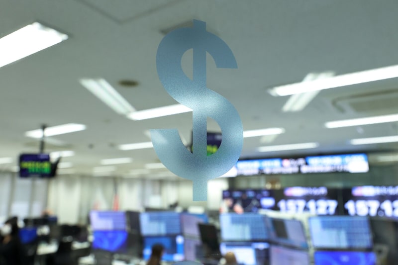 Un símbolo de dólar estadounidense en una puerta de vidrio de una corredora de divisas en Tokio. Un símbolo de dólar estadounidense en una puerta de vidrio de una corredora de divisas en Tokio.