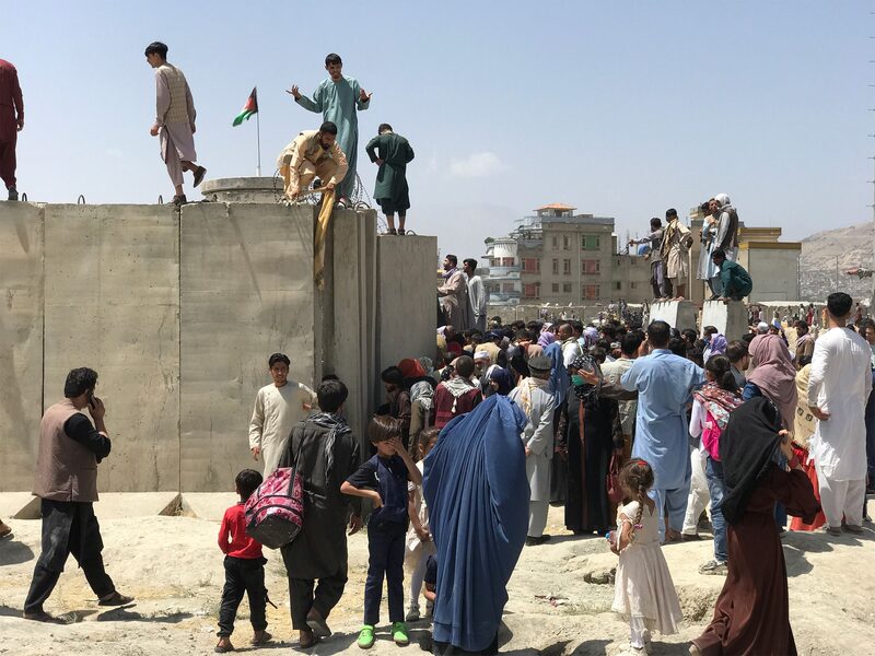 People struggle to cross the boundary wall of Hamid Karzai International Airport to flee the country after rumors that foreign countries are evacuating people even without visas, after the Taliban over run of Kabul, Afghanistan. People struggle to cross the boundary wall of Hamid Karzai International Airport to flee the country after rumors that foreign countries are evacuating people even without visas, after the Taliban over run of Kabul, Afghanistan.