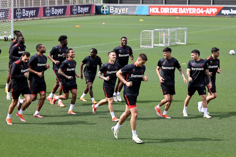 Time de futebol em campo. São 13 homens de uniforme preto correndo Time de futebol em campo. São 13 homens de uniforme preto correndo