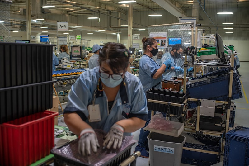 Workers package television remote controls at the SMK Corp. factory in Tijuana, Mexico, on Thursday, Sep. 9, 2021. Scores of companies across Tijuana found reasons to stay open throughout the pandemic. So did large parts of the rest of Baja California and other northern states, spurred by U.S. demand for Mexican-produced goods that had been supercharged by stimulus payments from the Trump and then the Biden administrations. Photographer: Alejandro Cegarra/Bloomberg Workers package television remote controls at the SMK Corp. factory in Tijuana, Mexico, on Thursday, Sep. 9, 2021. Scores of companies across Tijuana found reasons to stay open throughout the pandemic. So did large parts of the rest of Baja California and other northern states, spurred by U.S. demand for Mexican-produced goods that had been supercharged by stimulus payments from the Trump and then the Biden administrations. Photographer: Alejandro Cegarra/Bloomberg