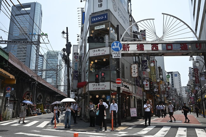 Unos peatones esperan en un paso de cebra en el barrio de Shimbashi, en Tokio (Japón). Unos peatones esperan en un paso de cebra en el barrio de Shimbashi, en Tokio (Japón).