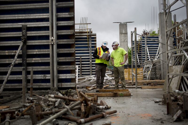 Workers go over paperwork at a condominium construction site. Workers go over paperwork at a condominium construction site.