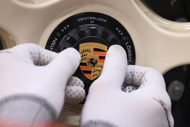 Un trabajador coloca una insignia en la rueda de un automóvil Porsche 911 ST. Fotógrafo: Krisztian Bocsi/Bloomberg Un trabajador coloca una insignia en la rueda de un automóvil Porsche 911 ST. Fotógrafo: Krisztian Bocsi/Bloomberg