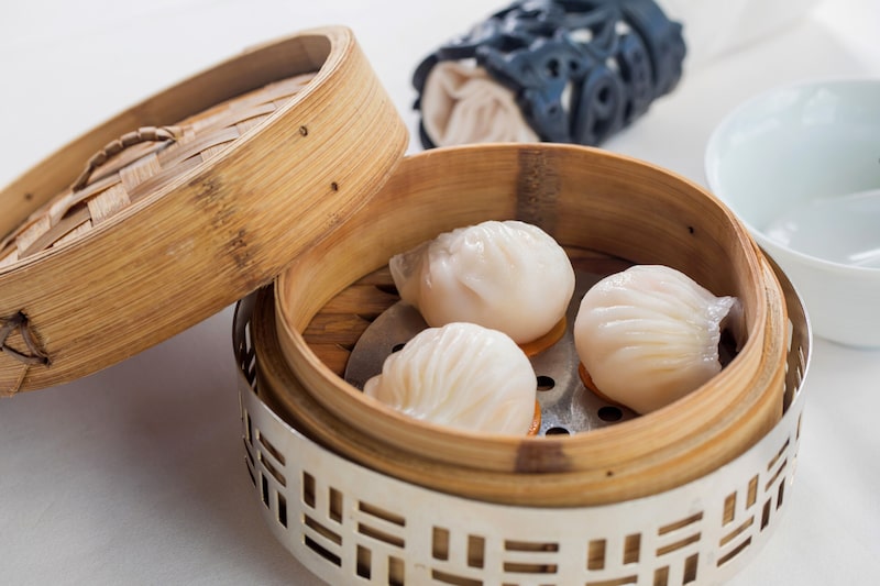 Foto de uma cesta de bambu contendo três bolinhos típicos da culinária oriental Foto de uma cesta de bambu contendo três bolinhos típicos da culinária oriental