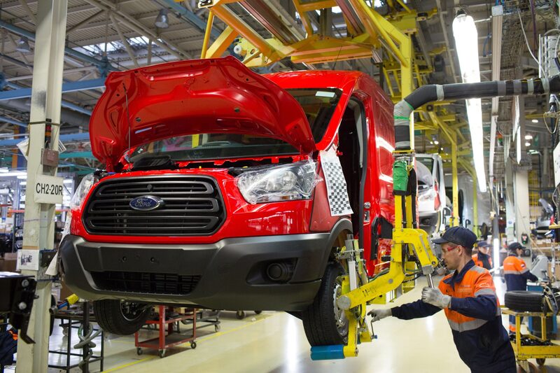 Un trabajador monta una rueda en una furgoneta Ford Transit en la línea de producción de la planta de producción de Ford. Un trabajador monta una rueda en una furgoneta Ford Transit en la línea de producción de la planta de producción de Ford.