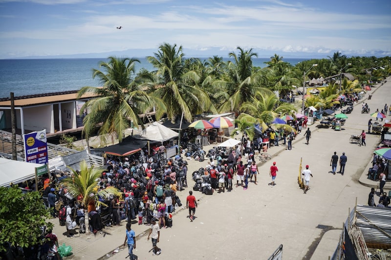 Migrantes esperan para abordar botes en un puerto de la región colombiana de Necoclí. Migrantes esperan para abordar botes en un puerto de la región colombiana de Necoclí.