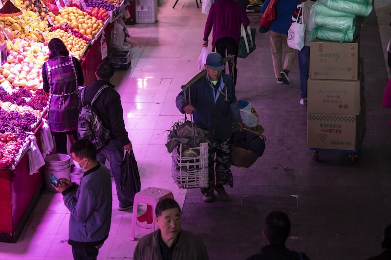 A shopper uses a bamboo pole to carry goods at a fresh food market in Shanghai, China, on Wednesday, Nov. 3, 2021. A shopper uses a bamboo pole to carry goods at a fresh food market in Shanghai, China, on Wednesday, Nov. 3, 2021.